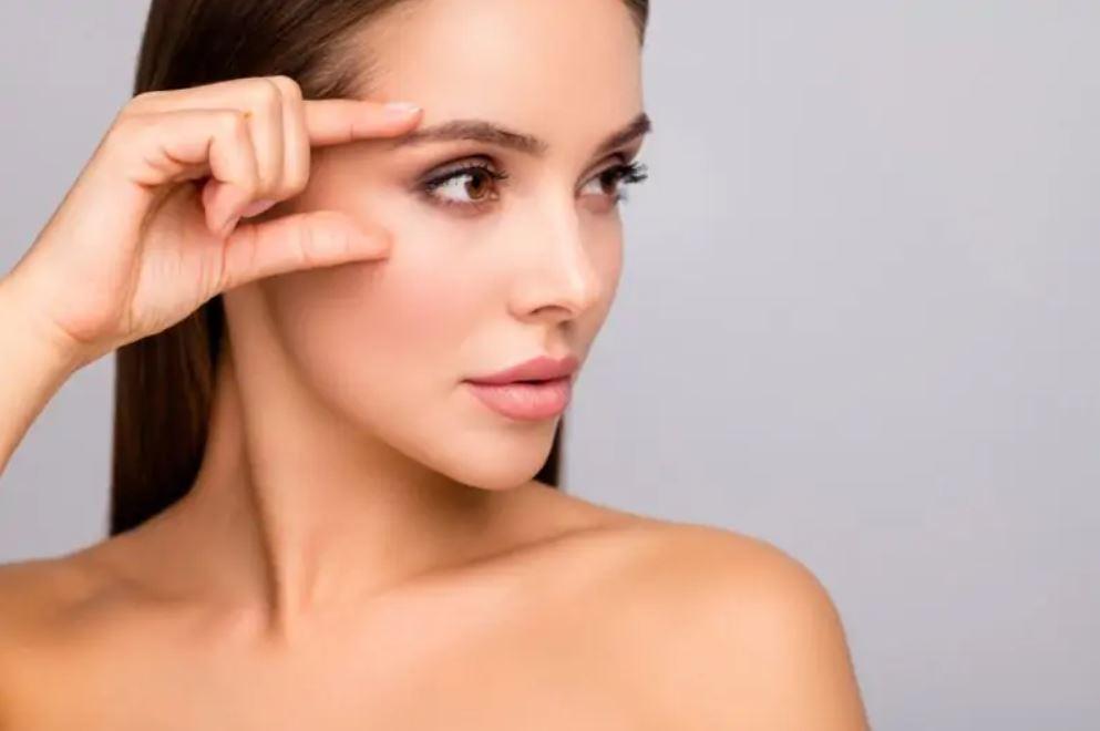 woman putting her hand near her brows